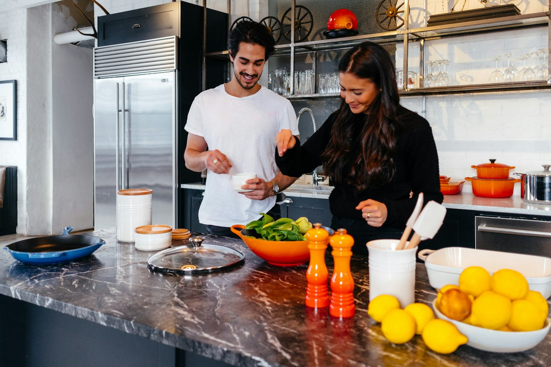 Una pareja cocina junta en la cocina de su casa