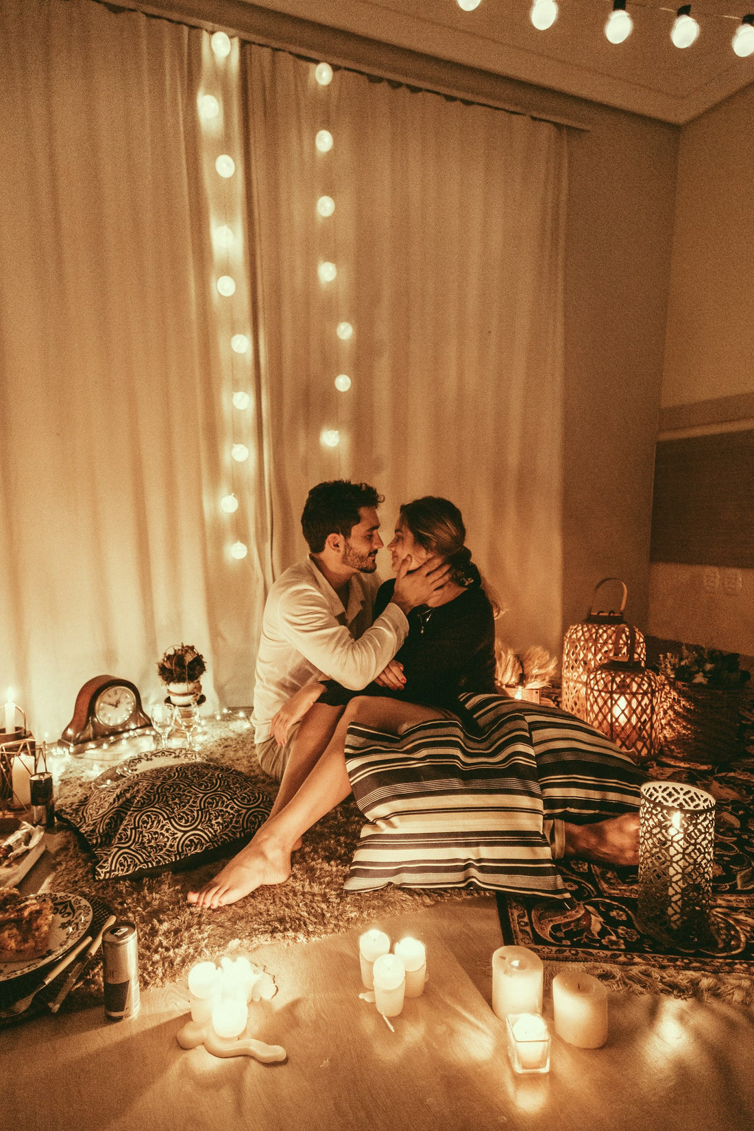 Una pareja sentada en el piso entre velas encendidas
