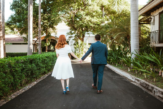 Una pareja camina de la mano por un camino arbolado